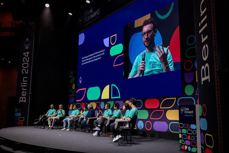 Flink Forward 2024 PMC Panel sit in a row onstage.